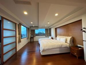 um quarto com uma cama grande e uma janela grande em 德隆行館 em Yilan City