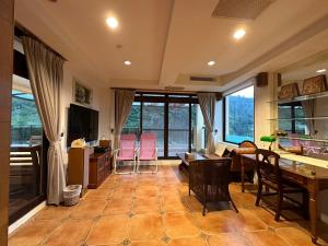 een woonkamer met een bank en een tafel en stoelen bij 德隆行館 in Yilan