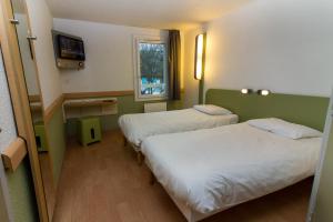 a hotel room with two beds and a window at Ibis Budget Boulogne-Sur-Mer Centre les Ports in Boulogne-sur-Mer +48 photos
