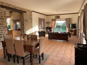 una sala da pranzo con tavolo e divano di Rural spacious bungalow with pool a Chalandrey
