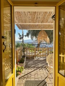 une porte ouverte sur une terrasse avec un parasol dans l'établissement Casa Malacitano, Caminito del Rey, à Valle de Abdalagís