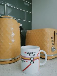 a coffee cup sitting on a counter next to two toasters at Cosy home entire house, sleeps 7 in Wyken