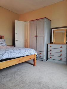 a bedroom with a bed and two dressers and a mirror at Cosy home entire house, sleeps 7 in Wyken