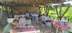 a group of people sitting at tables in a restaurant at Vinarija Stojanovic in Slankamenački Vinogradi
