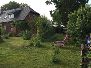 un banco rojo sentado en el patio de una casa en Zum Schwalbennest, en Wredenhagen