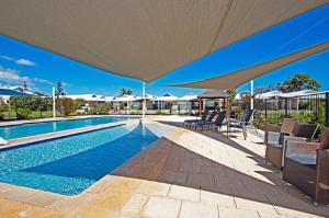 a swimming pool with a large umbrella over it at Turquoise Escape in Jurien Bay