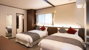 富士河口湖的住宿－HOTORI no HOTEL BAN，酒店客房,设有两张床和镜子