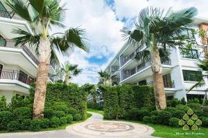 a building with palm trees in front of it at Title III and II by Villacarte in Rawai Beach +9 photos