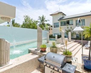 a backyard with a grill and a swimming pool at Mantra in the Village in Port Douglas