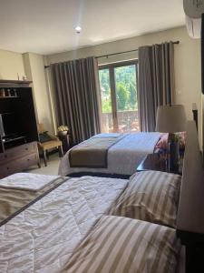 a hotel room with two beds and a window at Carol Crosswinds Tagaytay in Cavite