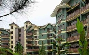a large green building with balconies on it at Carol Crosswinds Tagaytay in Cavite