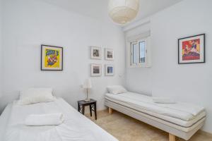 Cette chambre blanche comprend deux lits et une table. dans l'établissement Fuengirola apartment close to the beach Ref 06, à Torremolinos