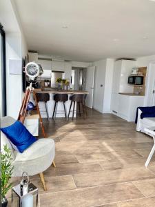 een woonkamer met een houten vloer en een keuken bij Brand New Beachfront Ground floor with garden 2 Bed apartment 6 Guests in Bournemouth