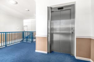 un corridoio con ascensore di metallo in un edificio di Hawkesbury Race Club Motel a Windsor