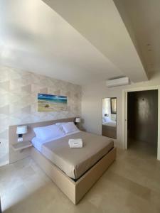 ein Schlafzimmer mit einem Bett in einem weißen Zimmer in der Unterkunft B&B La Porta sul Mare a Porto Cesareo in Torre Squillace