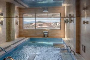 a swimming pool in a bathroom with a window at Apartamentos La Trufa Negra in Mora de Rubielos