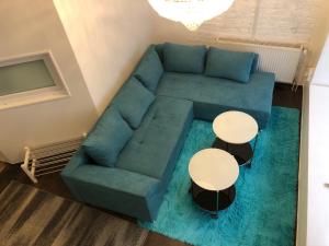 un soggiorno con divano blu e 2 tavoli di City-Apartment II Kreuzberg a Berlino