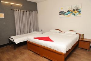 1 dormitorio con 2 camas con una manta roja. en Cosy Banjara Guest House, en Hyderabad