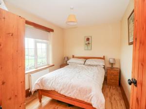 una camera con letto e finestra di The Granary a Castlerichard