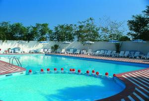 a large blue swimming pool with chairs at Hotel Bellevue Beach - sul mare in Milano Marittima