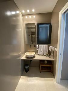 La salle de bains est pourvue d'un lavabo et d'un grand miroir. dans l'établissement B&B La Porta sul Mare a Porto Cesareo, à Torre Squillace