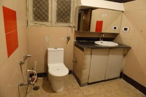 Baño pequeño con aseo y lavamanos en Cosy Banjara Guest House en Hyderabad