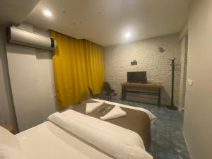 a room with two beds and a desk with a television at Bakırköy Macro Suite Otel in Istanbul