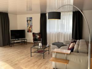 ein Wohnzimmer mit einem Sofa und einem Flachbild-TV in der Unterkunft Ferienwohnung Ricke in Krombach