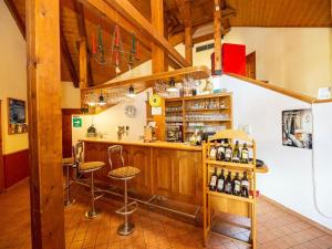 uma cozinha com um bar com bancos e garrafas de vinho em Hotel na Jezeře em Horní Planá