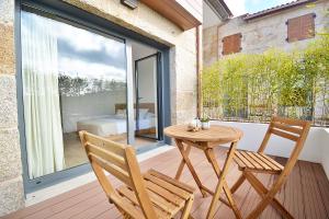 a wooden table and two chairs on a balcony at VILLA LAREDO *** in Armentera