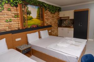 2 Betten in einem Zimmer mit Wandgemälde in der Unterkunft Heraldic Room Hotel in Esenyurt