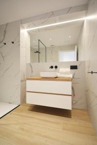 uma casa de banho branca com um lavatório e um espelho em VILLA LAREDO *** em Santa María