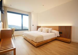 a bedroom with a bed and a large window at VILLA LAREDO *** in Armentera