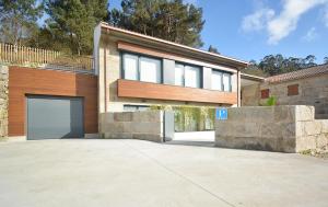 a house with a large garage in a driveway at VILLA LAREDO *** in Armentera