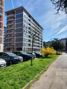 a tree in the grass in front of a building at Milano SanSiroHouse Rho MI Fiera in Milan