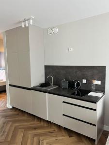 a kitchen with white cabinets and a black counter top at C4 Podgrzewany basen sauna, nowy Revist Szklarska in Szklarska Poręba