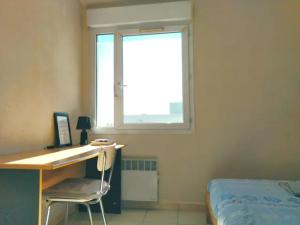 - une chambre avec un bureau, un lit et une fenêtre dans l'établissement Au cœur du grand Lyon à côté de la gare Part-Dieu, à Villeurbanne