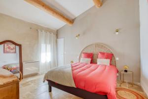 een slaapkamer met een groot bed met rode kussens bij Les Bellangers 1 - Piscine et Jacuzzi in Artigues