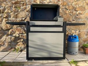 a television on a stand next to a stone wall at Canyelles BBQ Apartment in Lloret de Mar