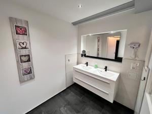 a white bathroom with a sink and a mirror at Familien-Studio in Schwerin