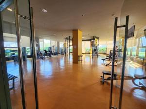 a large gym with a wooden floor and glass walls at Abode at The Radiance Manila Bay in Manila