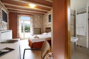 una camera d'albergo con letto e bagno di Albergo Garni Orchidea a Riva del Garda