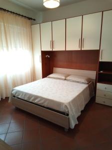 una camera da letto con un grande letto con armadi bianchi di Appartamento Loretta a Marciana Marina