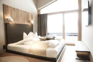 una camera da letto con un letto grande con una grande finestra di Walliserhof a Brand