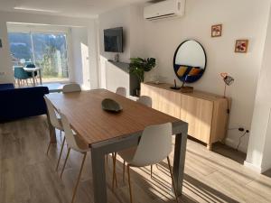 a dining room with a table and chairs and a mirror at Canyelles BBQ Apartment in Lloret de Mar