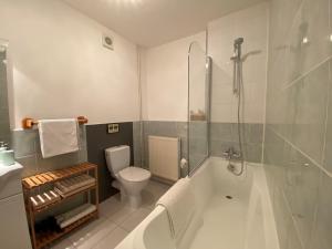 a bathroom with a tub and a toilet and a shower at L'Envers in Abzac