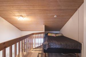 a bed in a room with a wooden ceiling at Holiday Home Tintintaival in Tahkovuori