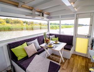 een kamer met een bank en een tafel op een boot bij Hausboot FIONA im Yachthafen Berlin - Schmöckwitz - Spree und Müggelsee in Berlijn