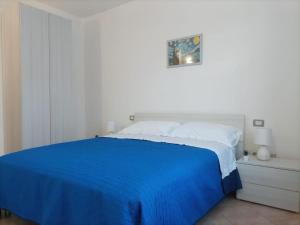um quarto branco com uma cama com lençóis azuis em Chilù em Cagliari