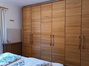 a large wooden cabinet in a bedroom with a bed at Akelei in Obermaiselstein